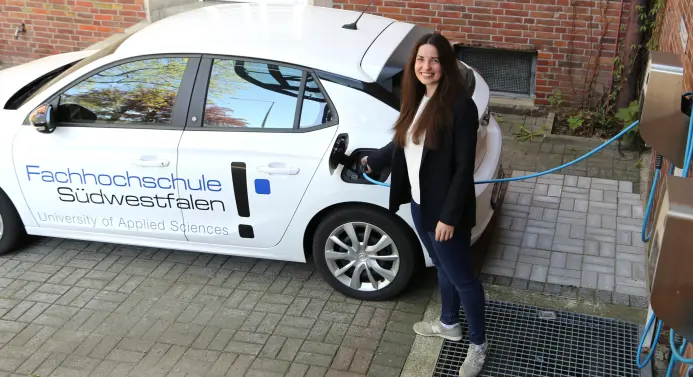 Eine Frau lädt ein Elektro-Auto.