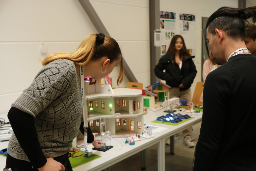 Young woman explaining model with burning green lights